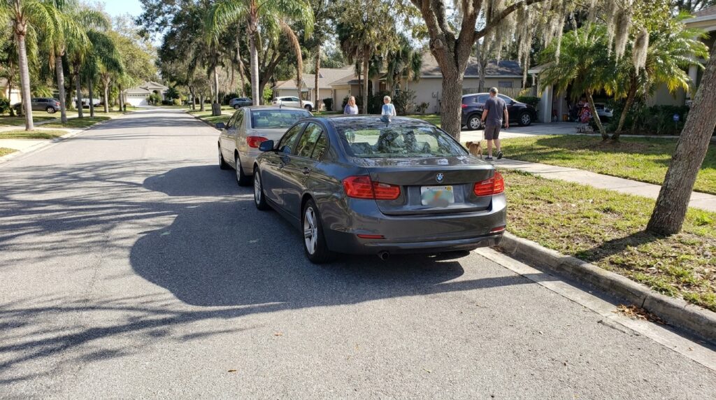 BMW sedan stopped on residential street near curb following rear-end collision
